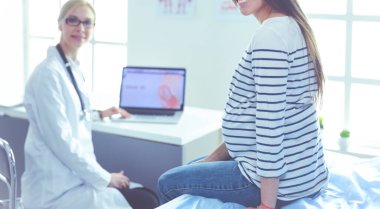 Hastanede doktorla gülümseyen güzel bir hamile kadın.