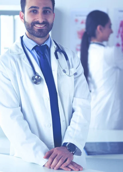 Attractive male doctor in front of medical group — Stock Photo, Image