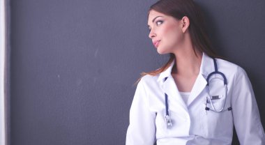 Bir dizüstü bilgisayar, gri arka plan üzerinde ayakta tutan genç kadın