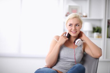 genç güzel kadın evde kanepede oturan ve müzik dinleme