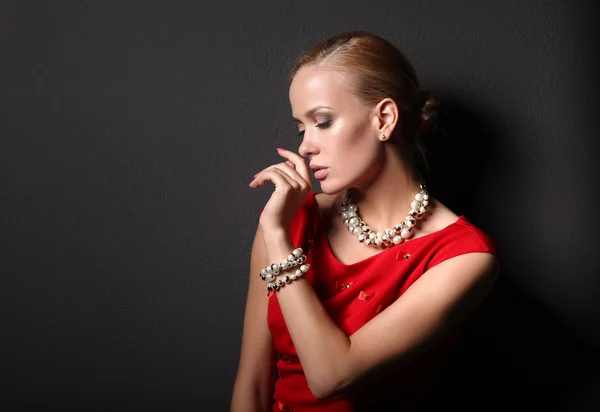 Young woman on red dress, isolated  black background — Stock Photo, Image