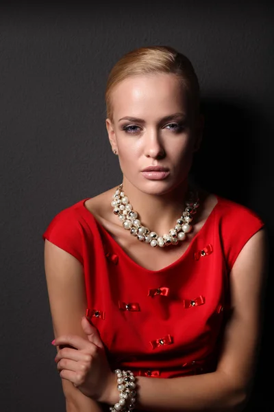 Jeune femme en robe rouge, fond noir isolé — Photo