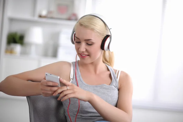 Joven hermosa mujer en casa sentada en el sofá y escuchando música —  Fotos de Stock