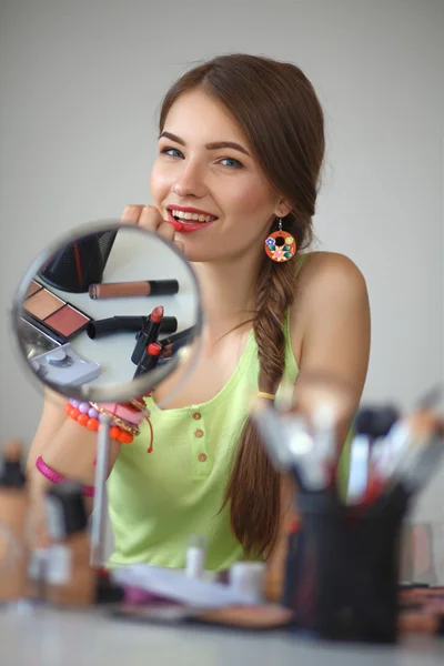 Молода красива жінка робить макіяж біля дзеркала — стокове фото