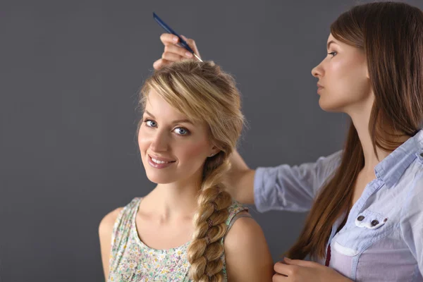 Mujer joven peluquera hacer peinado chica en el salón — Foto de Stock