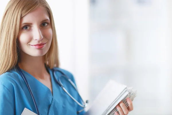 Retrato de doctora con carpeta en el pasillo del hospital —  Fotos de Stock