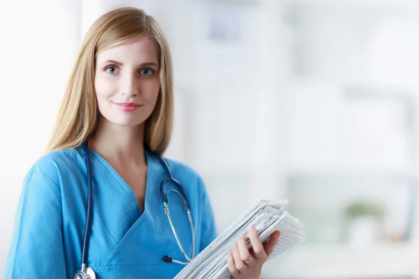 Portrait of woman doctor with folder at hospital corridor — Stock Photo, Image