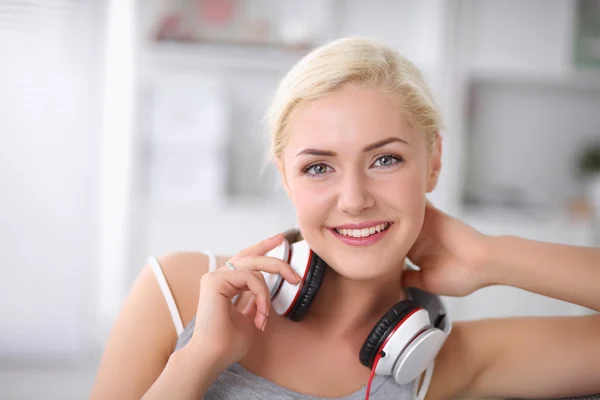 Young beautiful woman at home sitting on sofa and listening mus — Stock Photo, Image