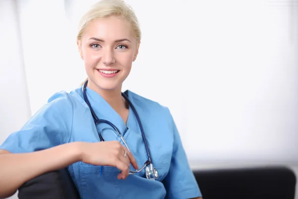 Retrato de un joven médico feliz sentado en el sofá — Foto de Stock