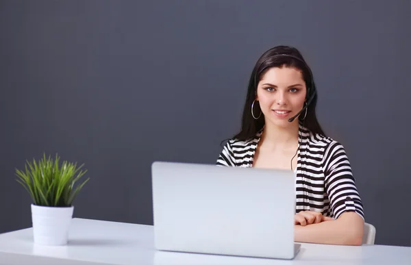 Schöne Geschäftsfrau arbeitet an ihrem Schreibtisch mit Headset und l — Stockfoto