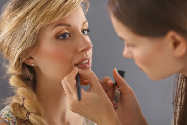 Künstlerin macht professionelles Make-up für Frauen — Stockfoto