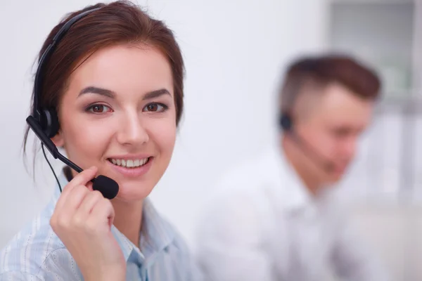 Donna d'affari con auricolare sorridente alla fotocamera nel call center — Foto Stock