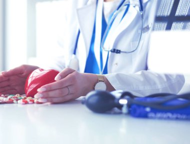 Masada kırmızı kalbi ve steteskopu olan kardiyolog.