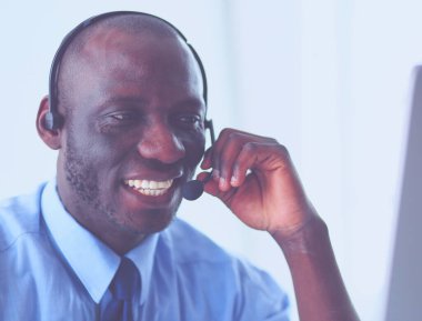 Kulaklıklı Afro-Amerikan işadamı laptopuyla çalışıyor.