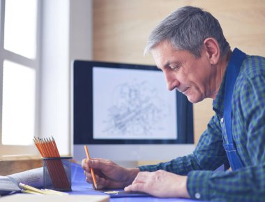 Ofisteki çizim masasında çalışan mimar