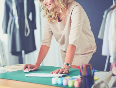 Moda tasarımcısı kadın stüdyoda tasarımları üzerinde çalışıyor.