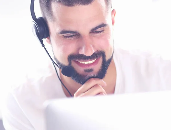 Ritratto di un giovane con un auricolare davanti a un computer portatile — Foto Stock