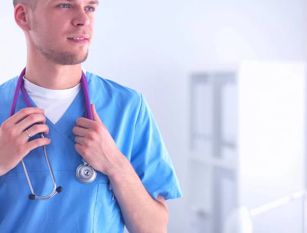 Läkare med stetoskop stående, korsade armar, isolerad på vit bakgrund — Stockfoto
