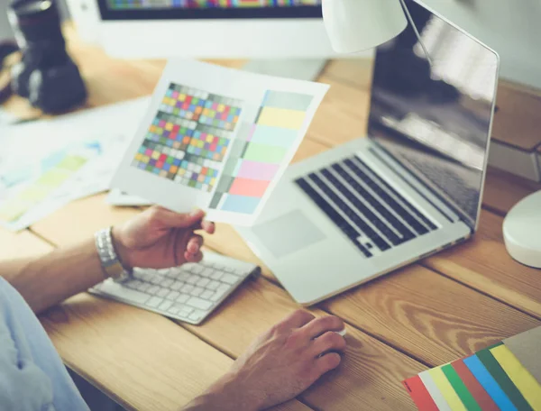 Porträt eines jungen Designers, der im Grafikstudio vor Laptop und Computer sitzt, während er online arbeitet — Stockfoto