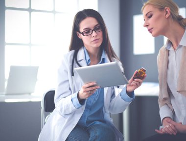 Doktor ve hasta masada otururken bir şey tartışıyorlar. İlaç ve sağlık hizmetleri kavramı