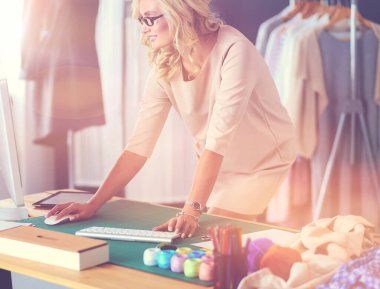 Moda tasarımcısı kadın stüdyoda tasarımları üzerinde çalışıyor..