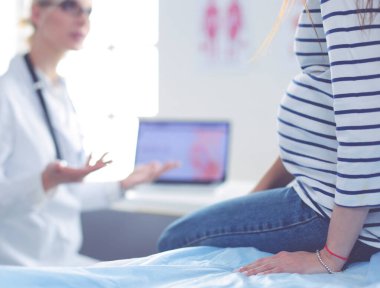 Hastanede doktorla gülümseyen güzel bir hamile kadın.