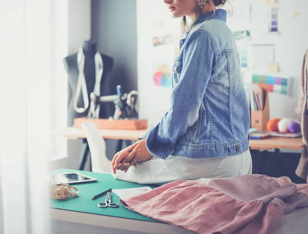 Moda tasarımcısı kadın stüdyoda tasarımları üzerinde çalışıyor.