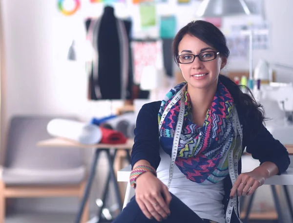 Hermoso diseñador de moda sentado en el escritorio en el estudio — Foto de Stock