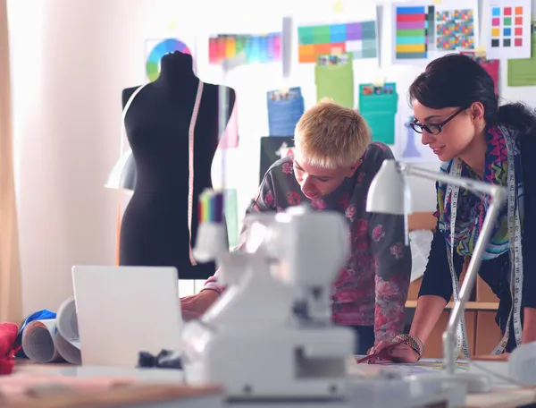 Молодой портниха разрабатывает шаблон одежды на бумаге — стоковое фото