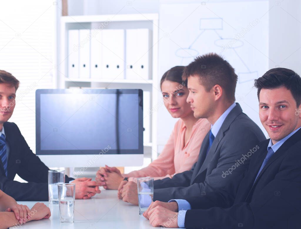 Business people sitting and discussing at business meeting, in office