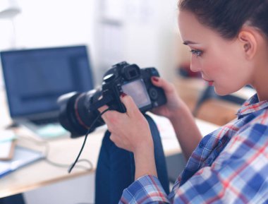 Masada dizüstü bilgisayarla oturan kadın fotoğrafçı.