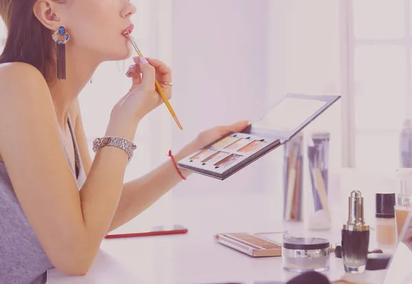 Brunett kvinna ansöker make up för en kväll datum framför en spegel — Stockfoto