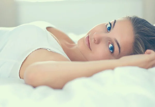 Gyönyörű fiatal nő fekszik az ágyban kényelmesen és boldogan — Stock Fotó
