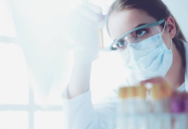 Hastanedeki kan örneğini analiz eden güzel bir kadın laboratuvar asistanı portresi.