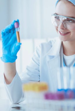 Laboratuvarda sıvı yeşil çözeltiye bakan bir tıbbi veya bilimsel araştırmacı ya da doktor