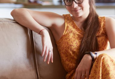 Kanepede oturan gülümseyen kadın portresi. Günlük tarz kapalı çekim.