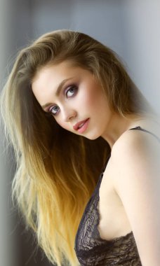 Genç kadın seksi kıyafeti içinde poz kameraya bakıyor