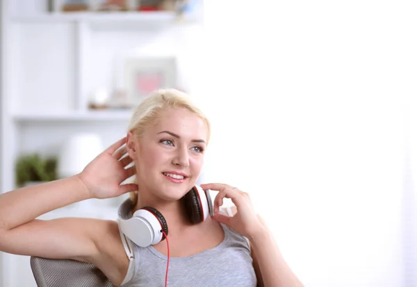 Jovem mulher bonita em casa sentado no sofá e ouvir música — Fotografia de Stock
