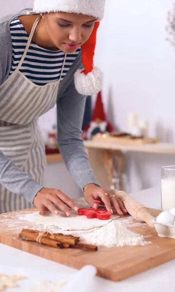 Женщина делает рождественское печенье на кухне — стоковое фото