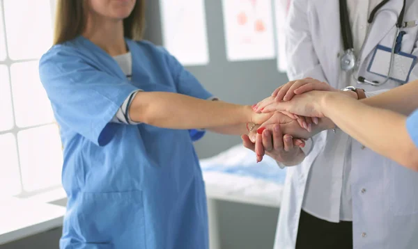 Läkare och sjuksköterskor i ett medicinskt team stapla händer — Stockfoto