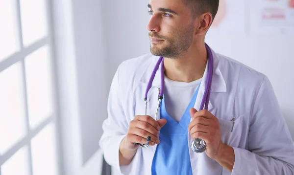 Fiatal és magabiztos férfi orvos portré áll orvosi rendelőben. — Stock Fotó