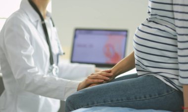 Hastanede doktorla gülümseyen güzel bir hamile kadın.