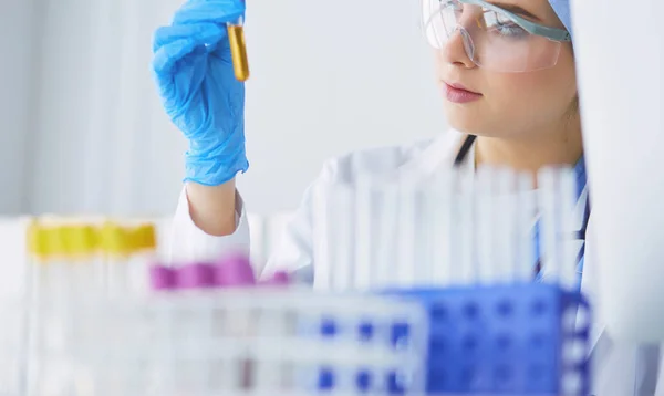 Asistente de laboratorio mujer analizando una muestra de sangre — Foto de Stock