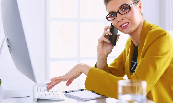 Donna d'affari che si concentra sul lavoro, utilizzando il computer e il cellulare in ufficio — Foto Stock