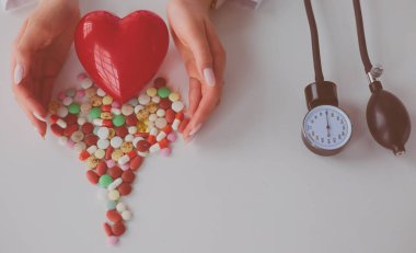 Masada kırmızı kalbi ve steteskopu olan kardiyolog.