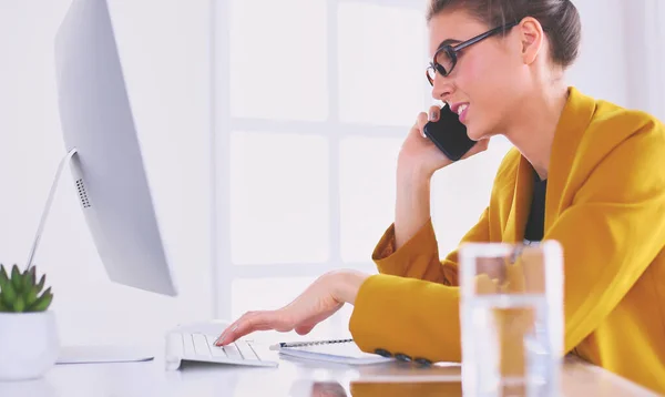 Retrato de una hermosa mujer haciendo una llamada mientras está sentada en su lugar de trabajo frente a la computadora portátil y trabajando en un nuevo proyecto —  Fotos de Stock