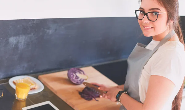 Mujer joven usando una tableta para cocinar en su cocina — Foto de Stock