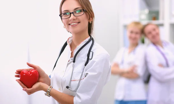 Médico com estetoscópio segurando coração, isolado em fundo branco — Fotografia de Stock