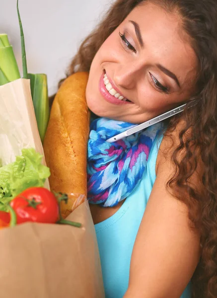 Young woman holding grocery shopping bag with vegetables Standing in the kitchen. — Stock Photo, Image