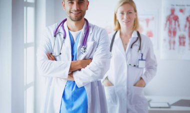 Genç ve kendinden emin doktorların portresi tıp ofisinde duruyor.